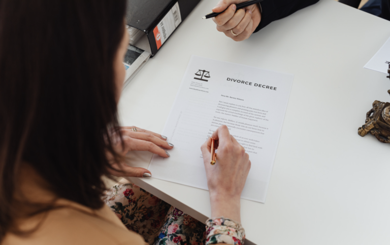 A person signing divorce papers, representing the expert guidance of family law solicitors in Newcastle and Maitland in handling separation, child custody, and ADR processes.