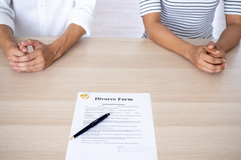 Two people with divorce papers, symbolising the completion of the divorce application process for separation, child custody, and property matters.