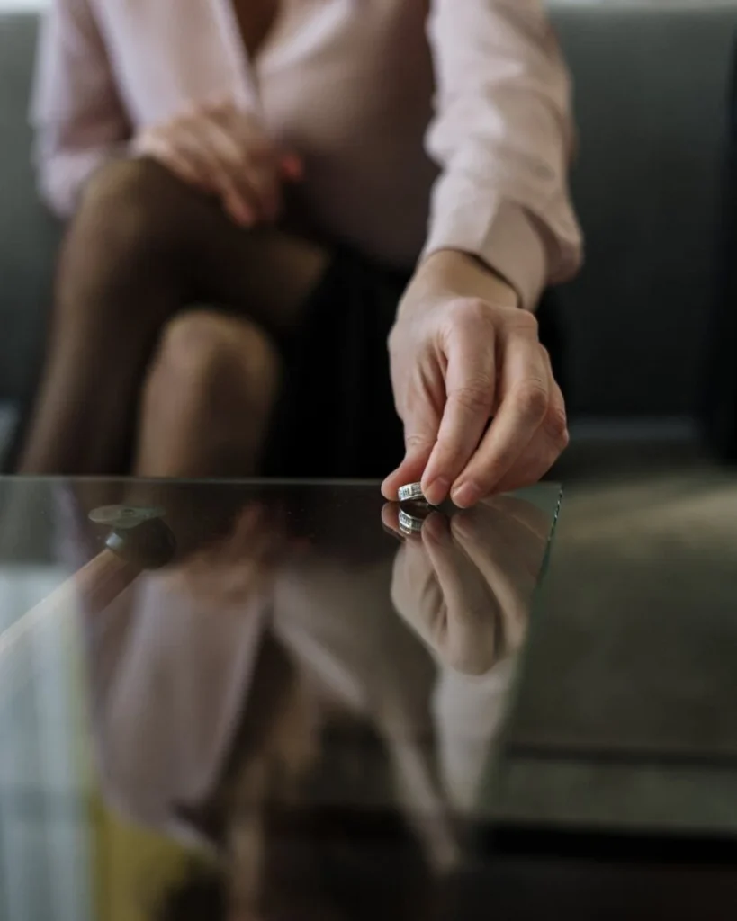 Person putting down wedding rings during divorce and property settlement process